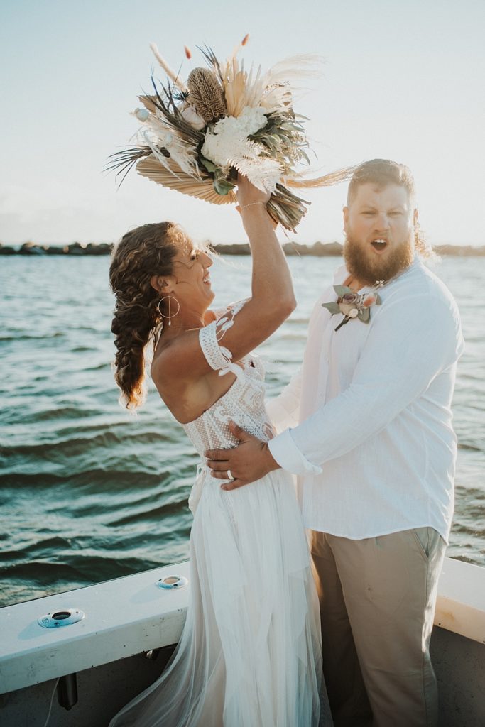 Bride and groom cheering on boat
