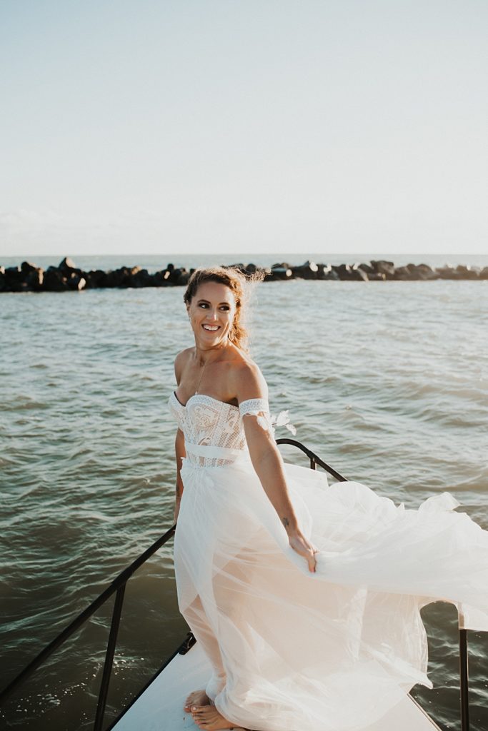 Flowing wedding dress on front of boat