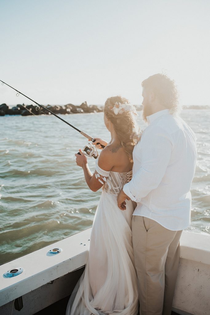 Bride and groom fishing on back of boat