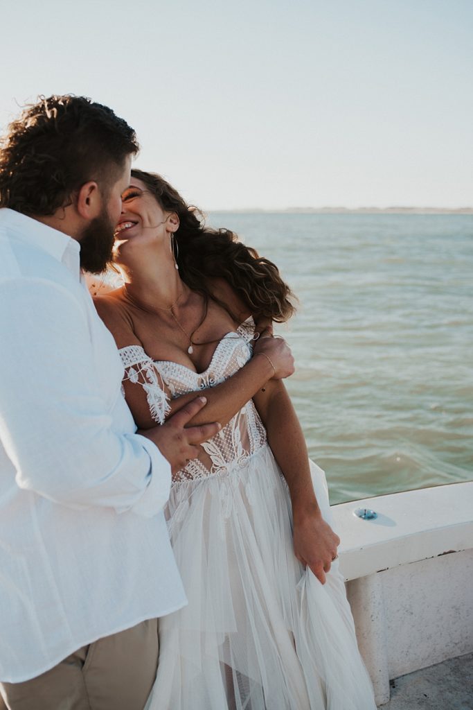Bride kissing groom on back of boat
