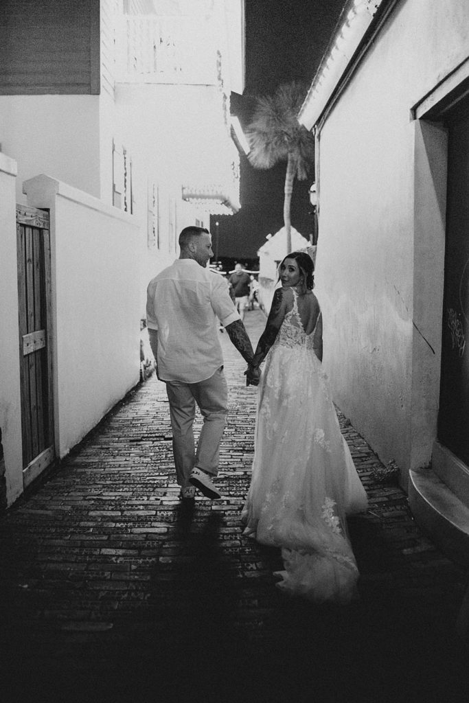 Groom leading bride down an alleyway in Saint Augustine
