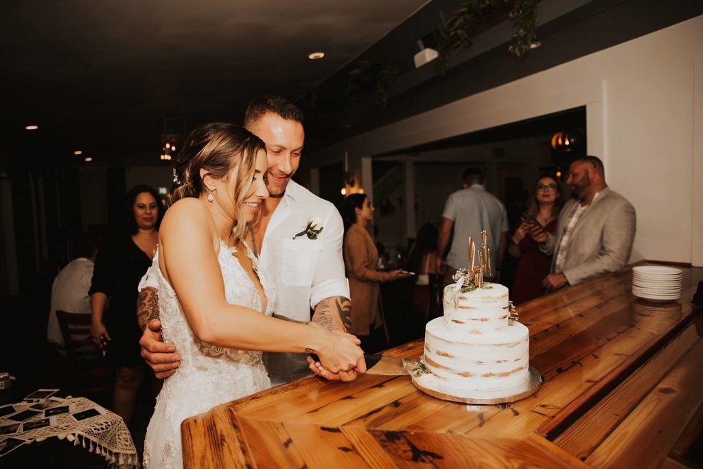 Bride and groom cutting rustic tiered wedding cake