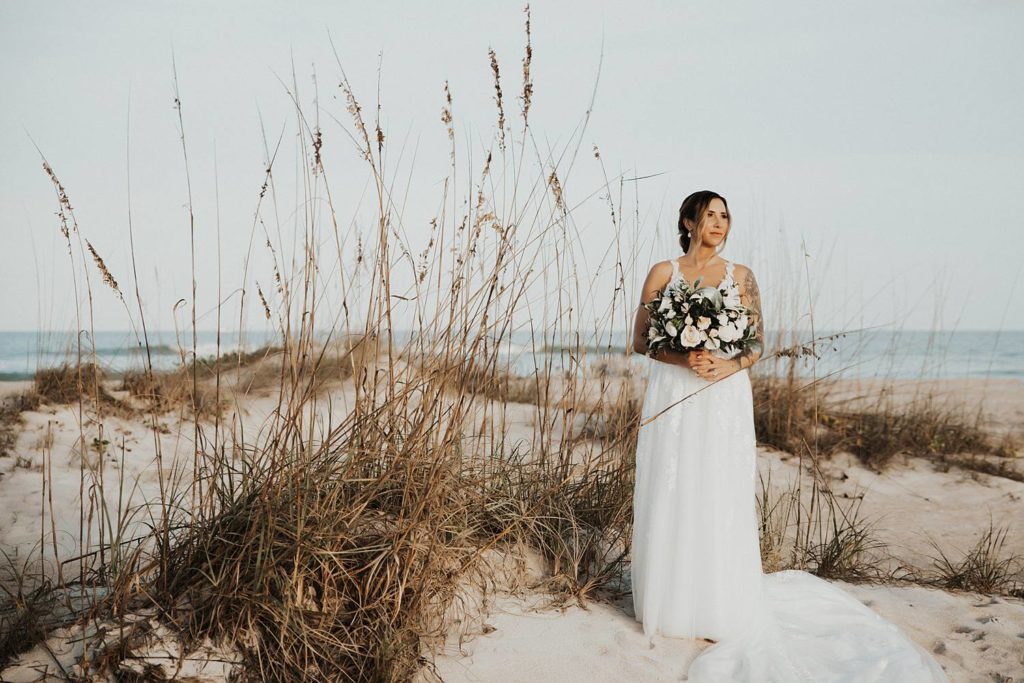 Bride holding bouquet on beach for bridal portraits