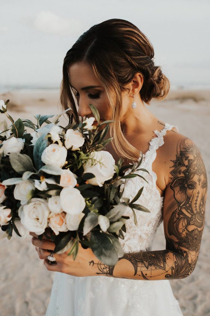 Bride smelling bouquet on Saint Anastasia beach