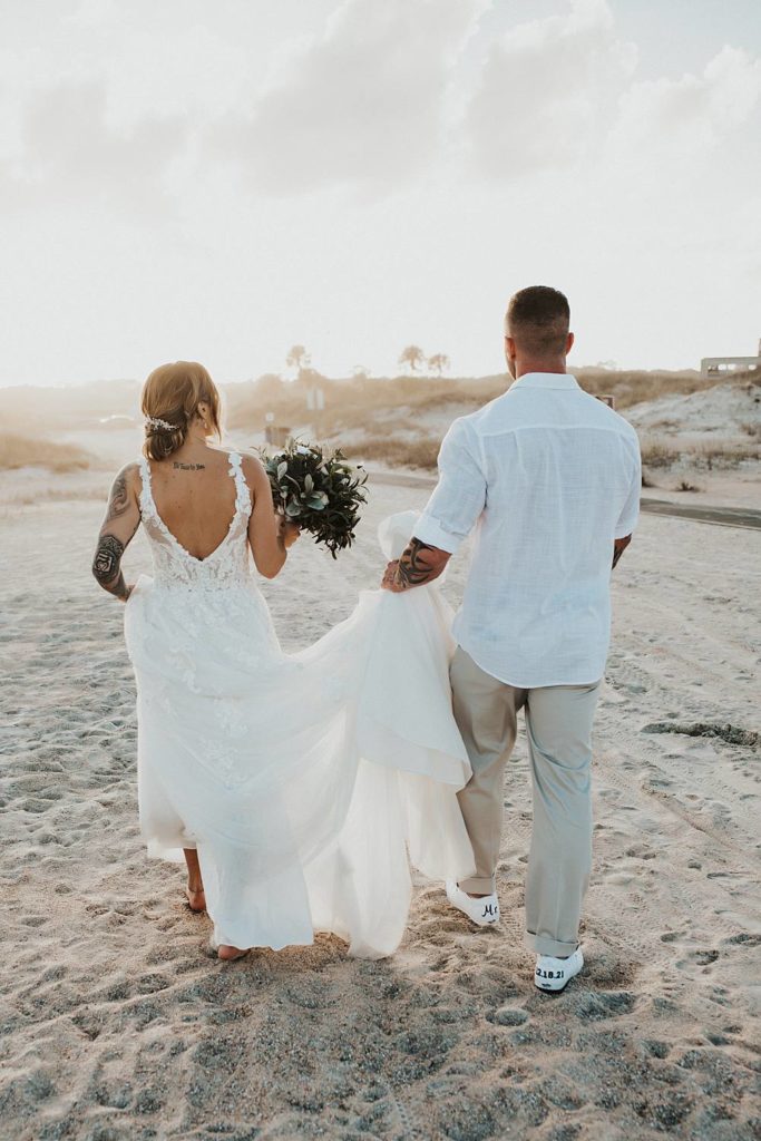 Bride and groom walking away on Saint Anastasia beach