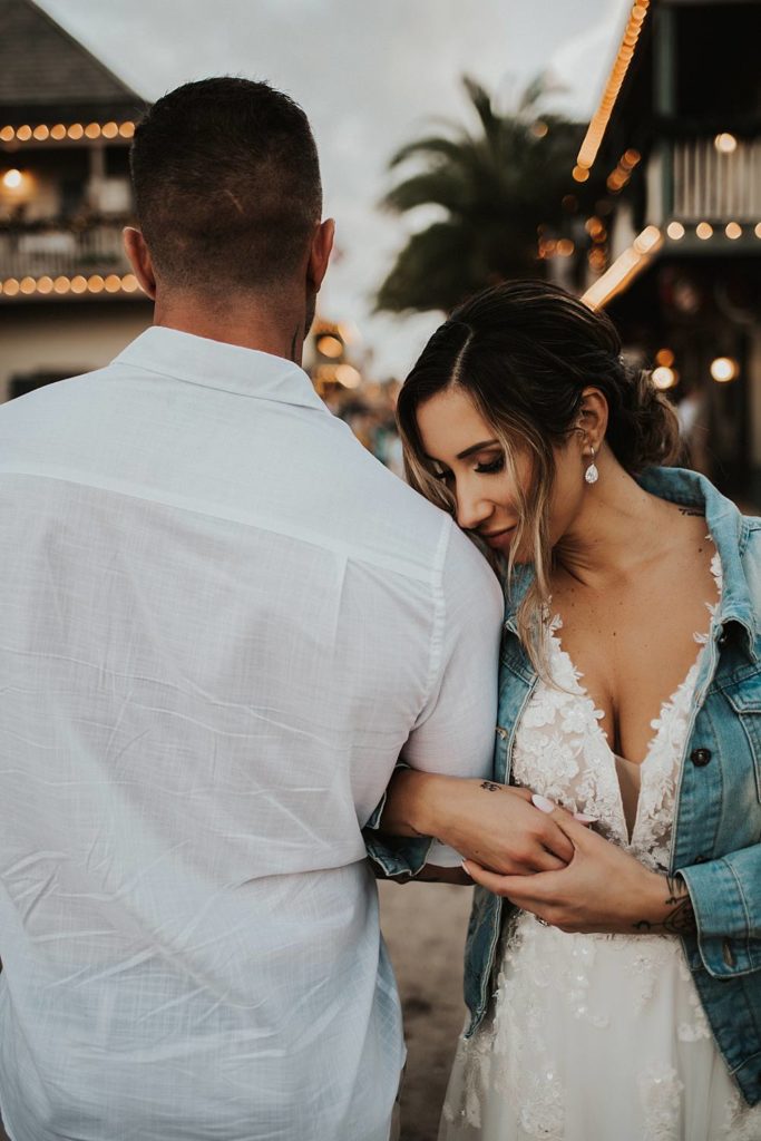 Bride cuddled into grooms arm in jean jacket