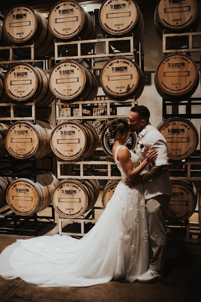 Bride and groom in front of whiskey barrels