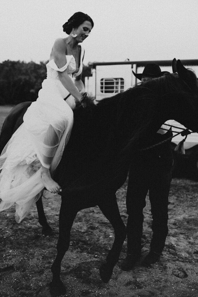 Bride riding her horse at the beach