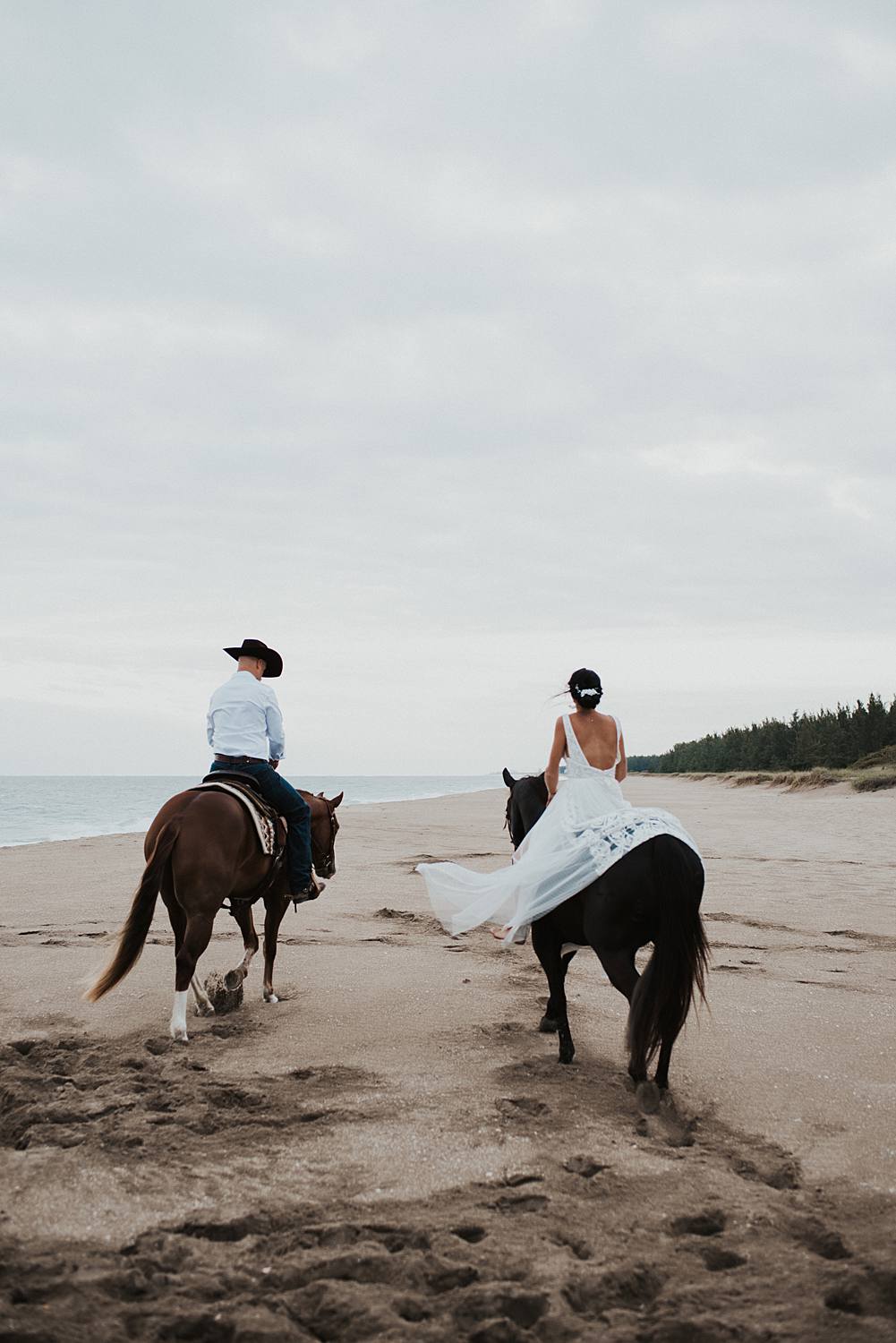 Bride and groom riding horses at the beach in Florida for their elopement