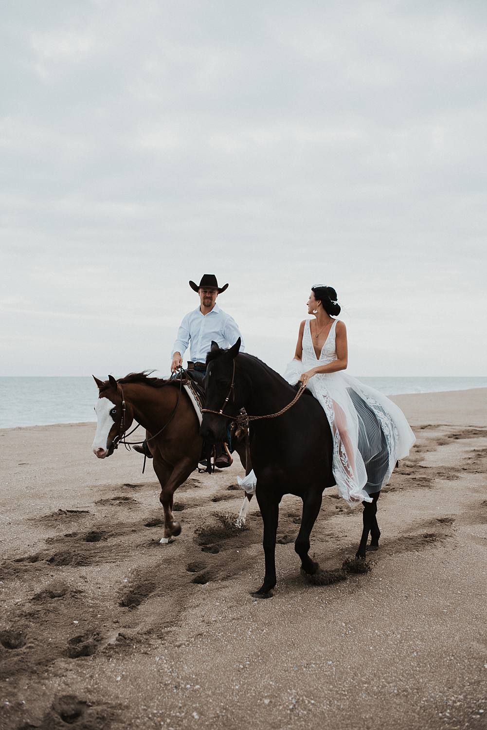 Bride and groom riding horses at the beach in Florida for their elopement