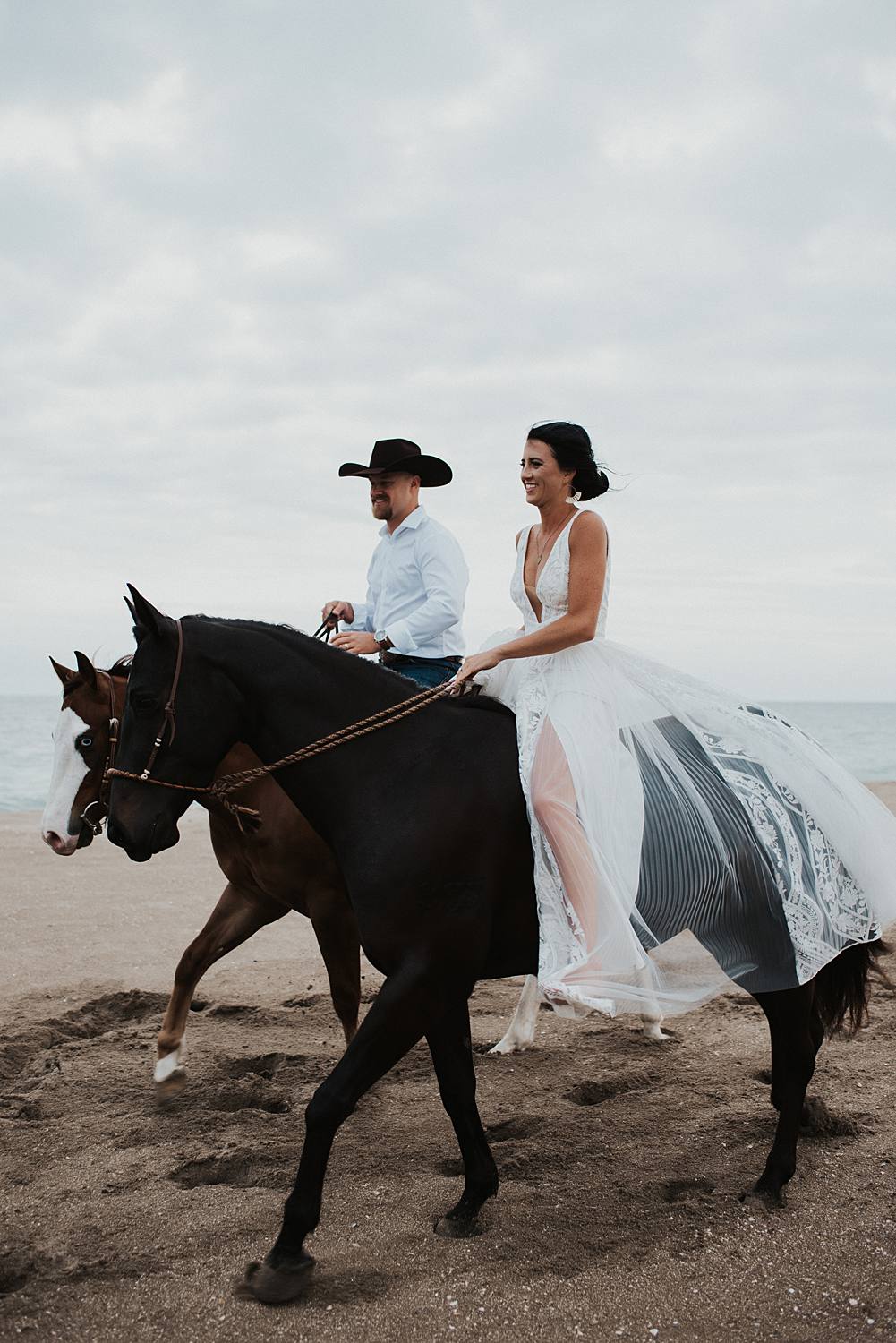 Bride and groom riding horses at the beach in Florida for their elopement