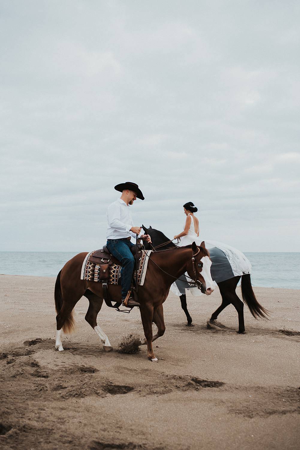 Bride and groom riding horses at the beach in Florida for their elopement