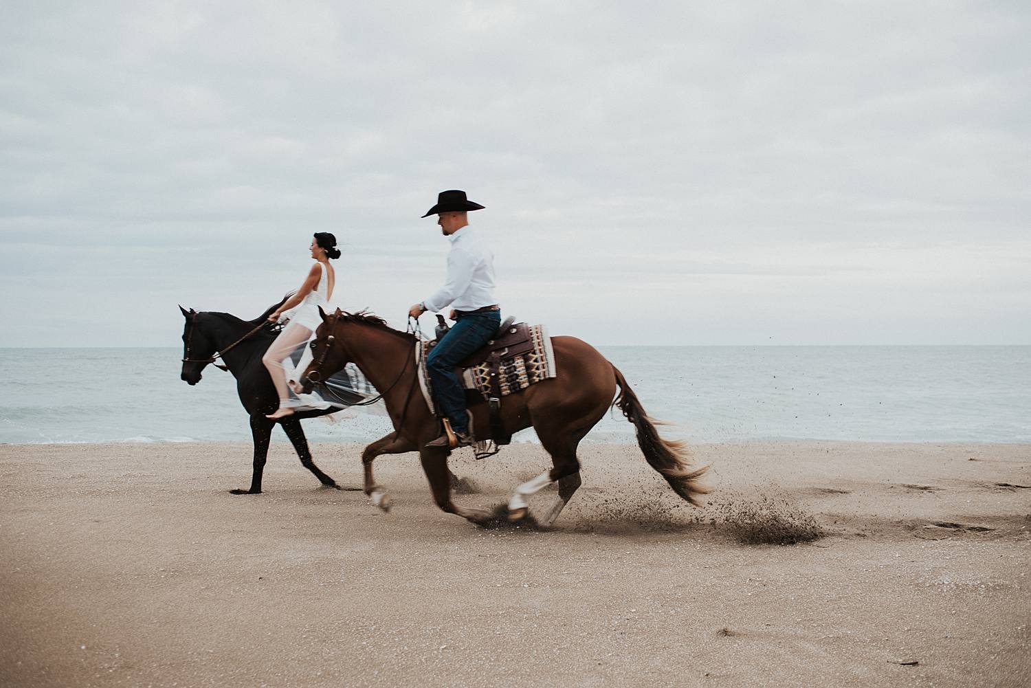 Bride and groom riding horses at the beach in Florida for their elopement