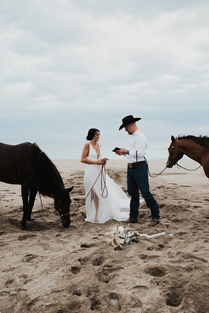 Bride and groom swapping vows on Florida beach during their elopement with their horses