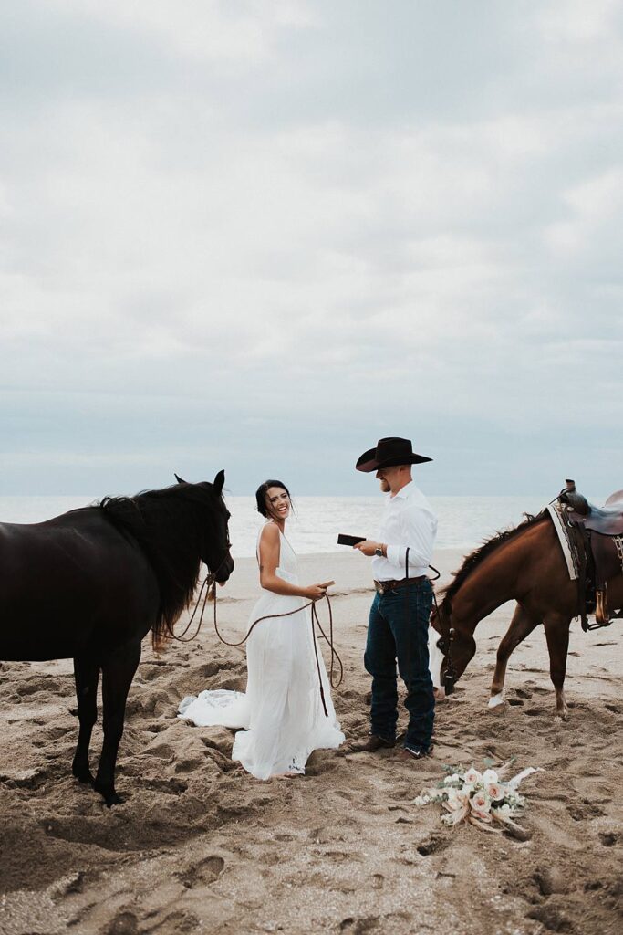 Bride and groom swapping vows on Florida beach during their elopement with their horses