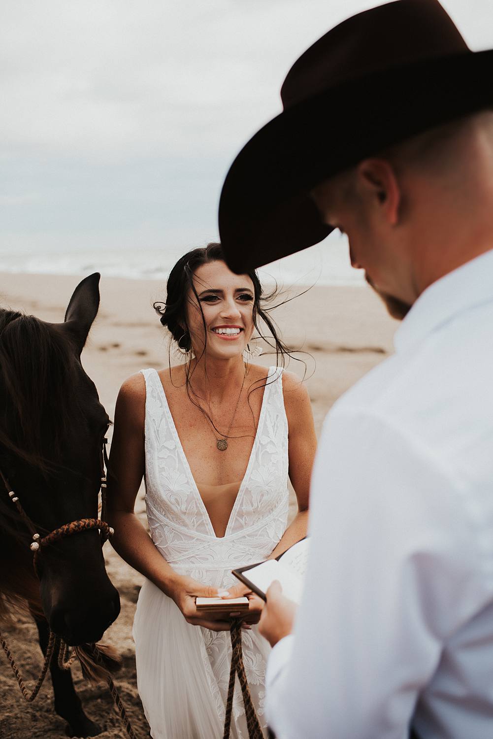 Bride and groom swapping vows on Florida beach during their elopement with their horses