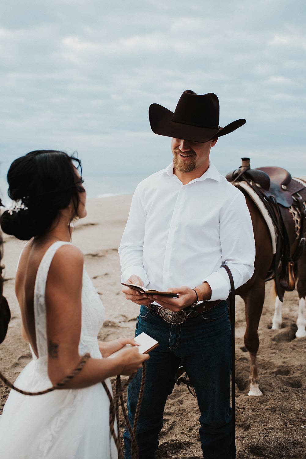 Bride and groom swapping vows on Florida beach during their elopement with their horses