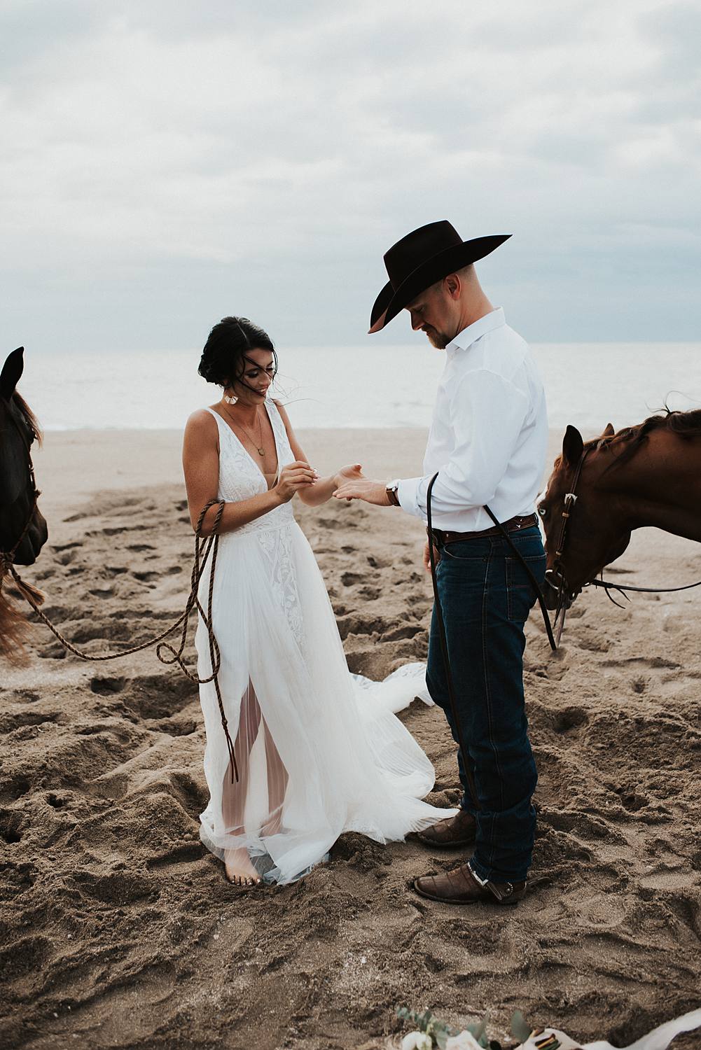 Bride and groom exchanging rings on Florida beach during their elopement with their horses