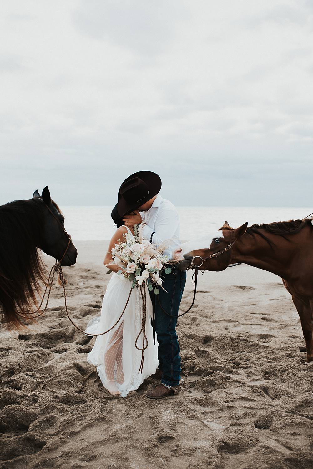 Bride and groom first kiss on Florida beach during their elopement with their horses