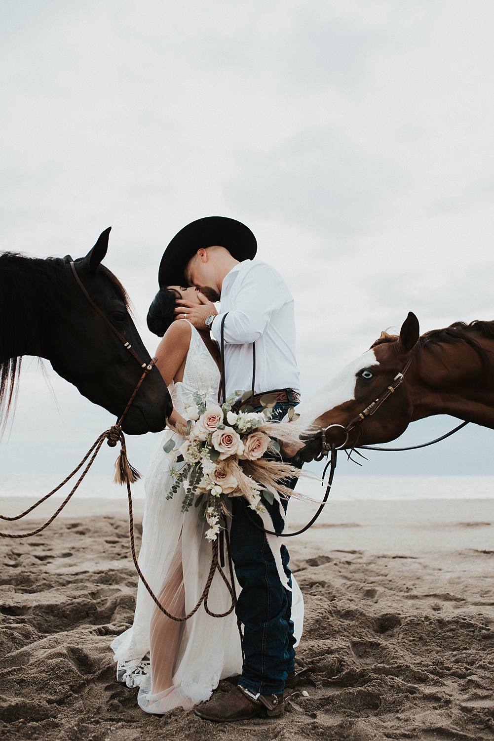 Bride and groom first kiss on Florida beach during their elopement with their horses