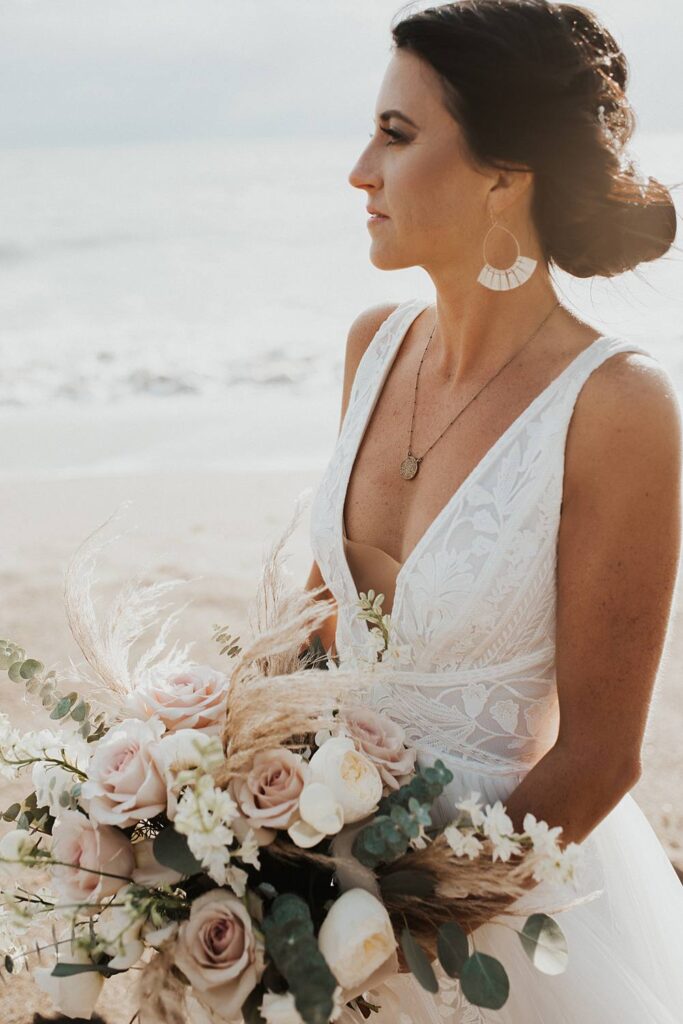 Bridal portrait on the beach at sunrise with neutral floral bouquet