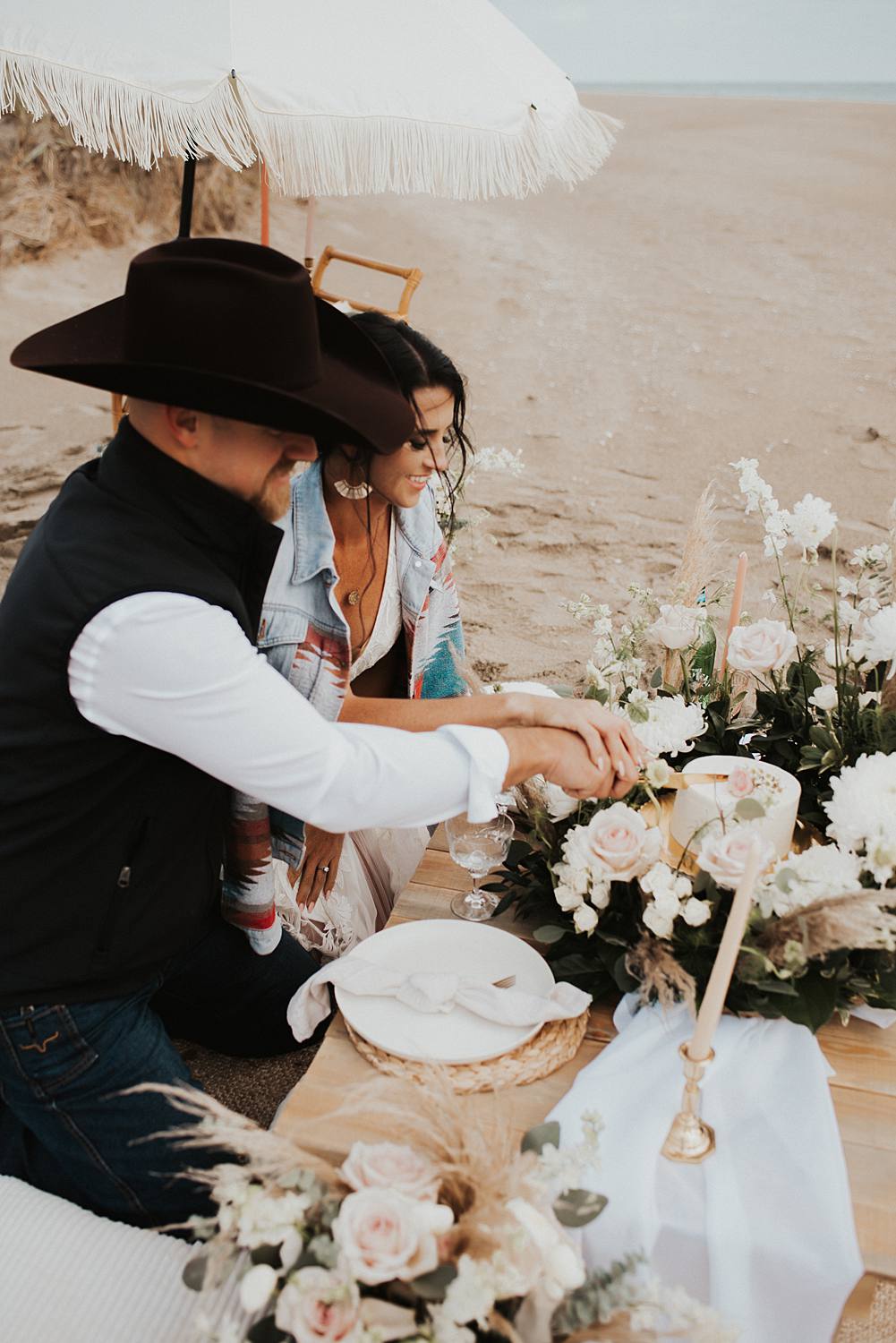 Bride and groom cutting their cake from their luxury picnic on the beach after their Florida elopement