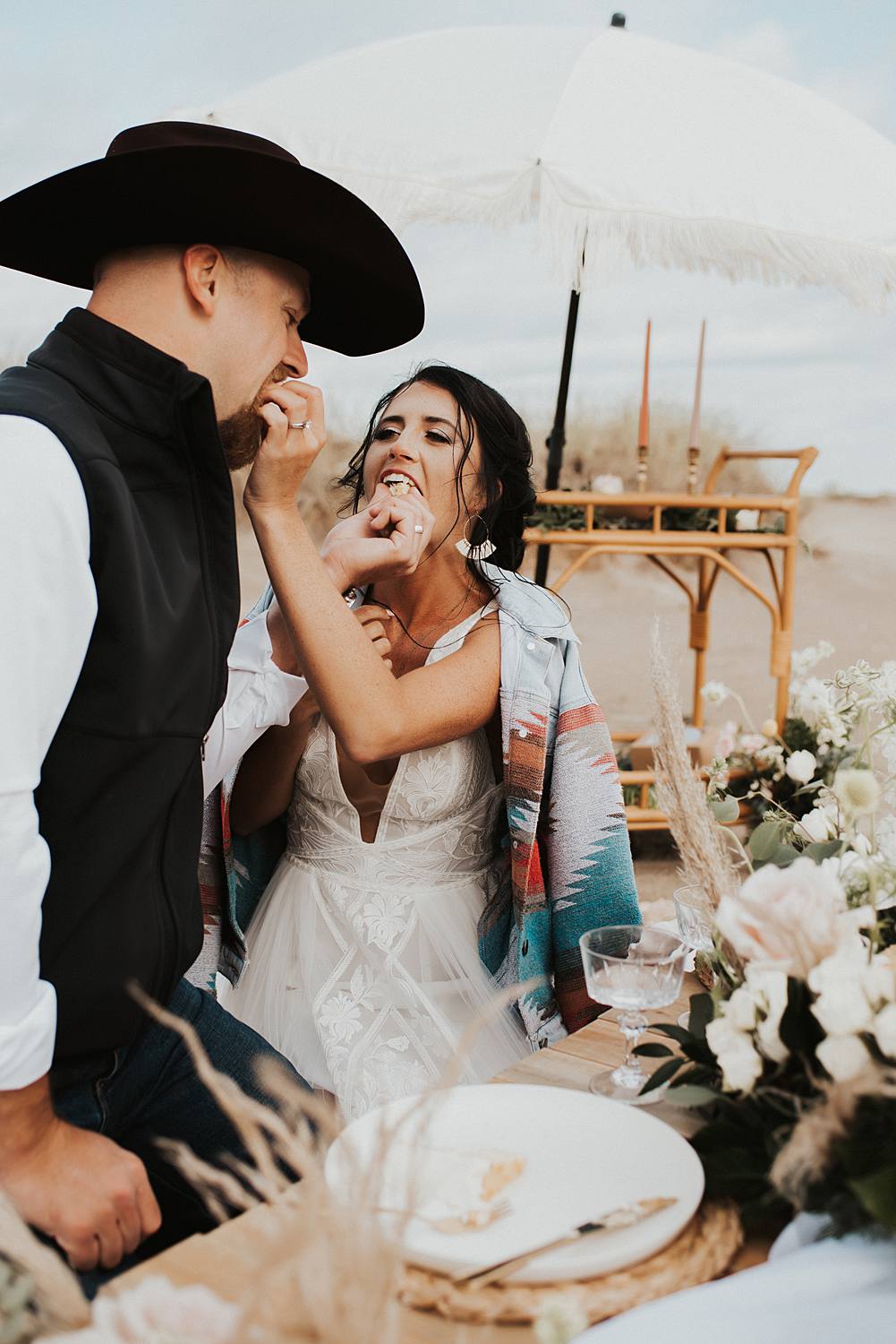 Bride and groom cutting their cake from their luxury picnic on the beach after their Florida elopement