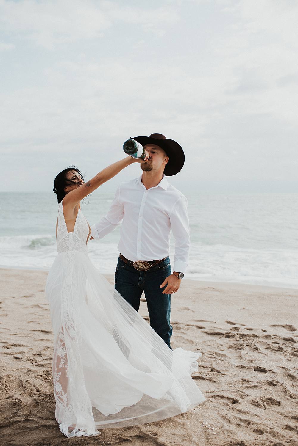 Bride and groom popping champagne on the beach after their Florida elopement