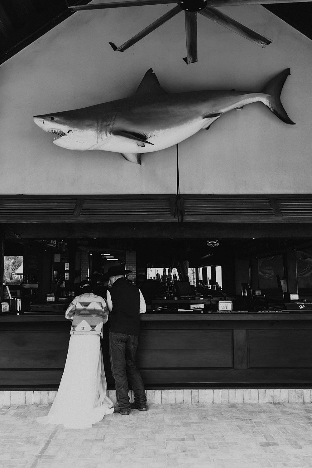 Bride and groom at beach bar for post celebratory drinks after their Florida beach elopement