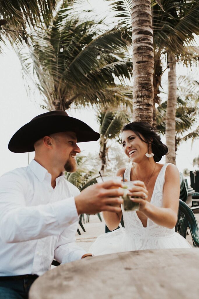 Bride and groom at beach bar for post celebratory drinks after their Florida beach elopement