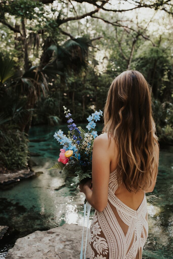 Bride in Rue De Seine dress with spring floral bouquet at Kelly Park Rock Springs in Apopka Florida during her elopement