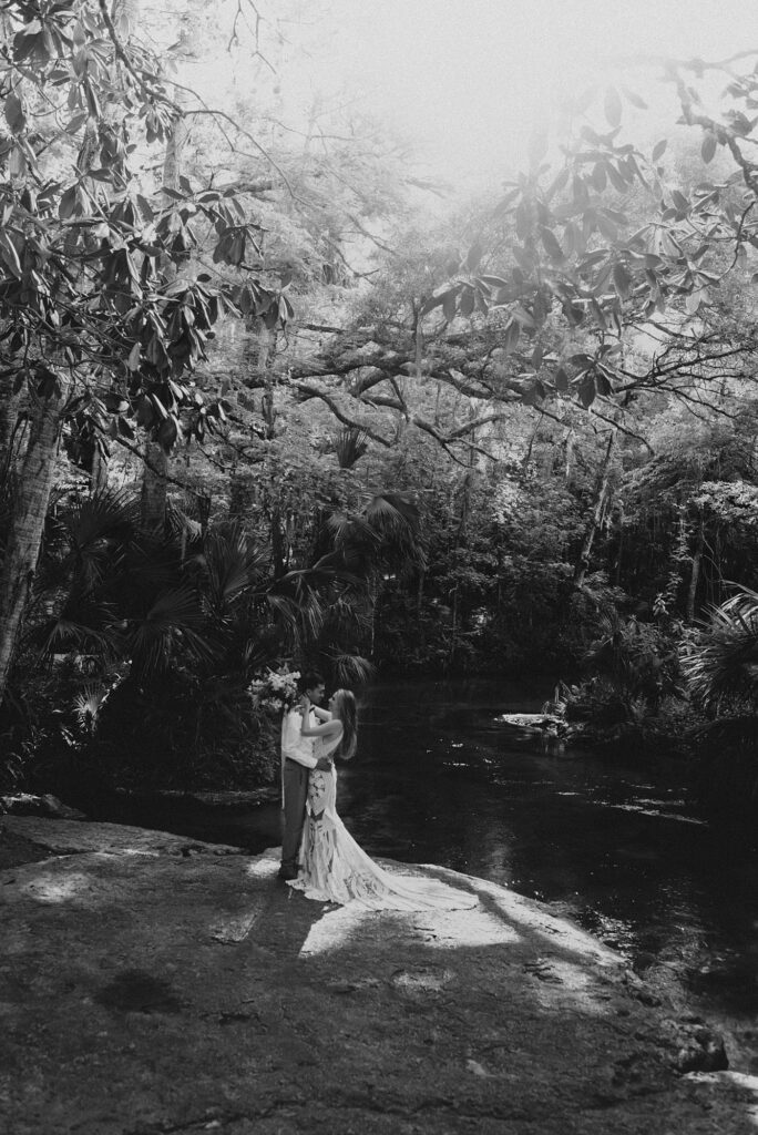 Bride and groom with spring floral bouquet at Kelly Park Rock Springs in Apopka Florida during her elopement
