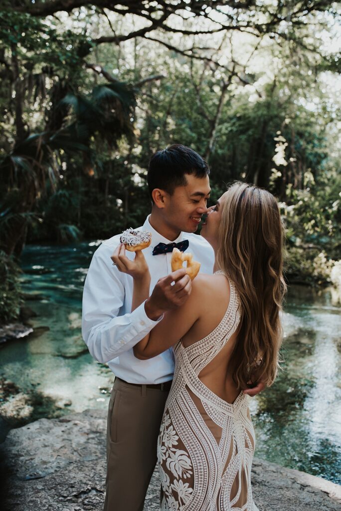 Bride and groom eating donuts at Kelly Park Rock Springs in Apopka Florida during her elopement