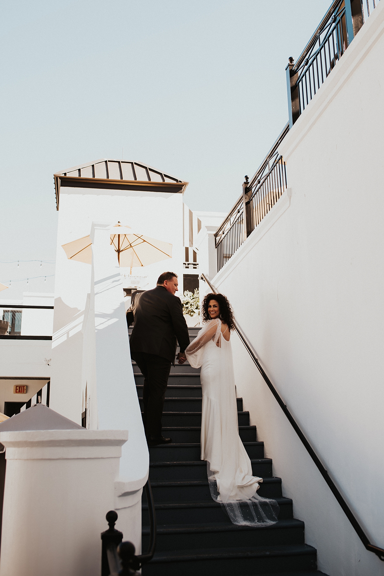 Bride and groom walking up white stairs