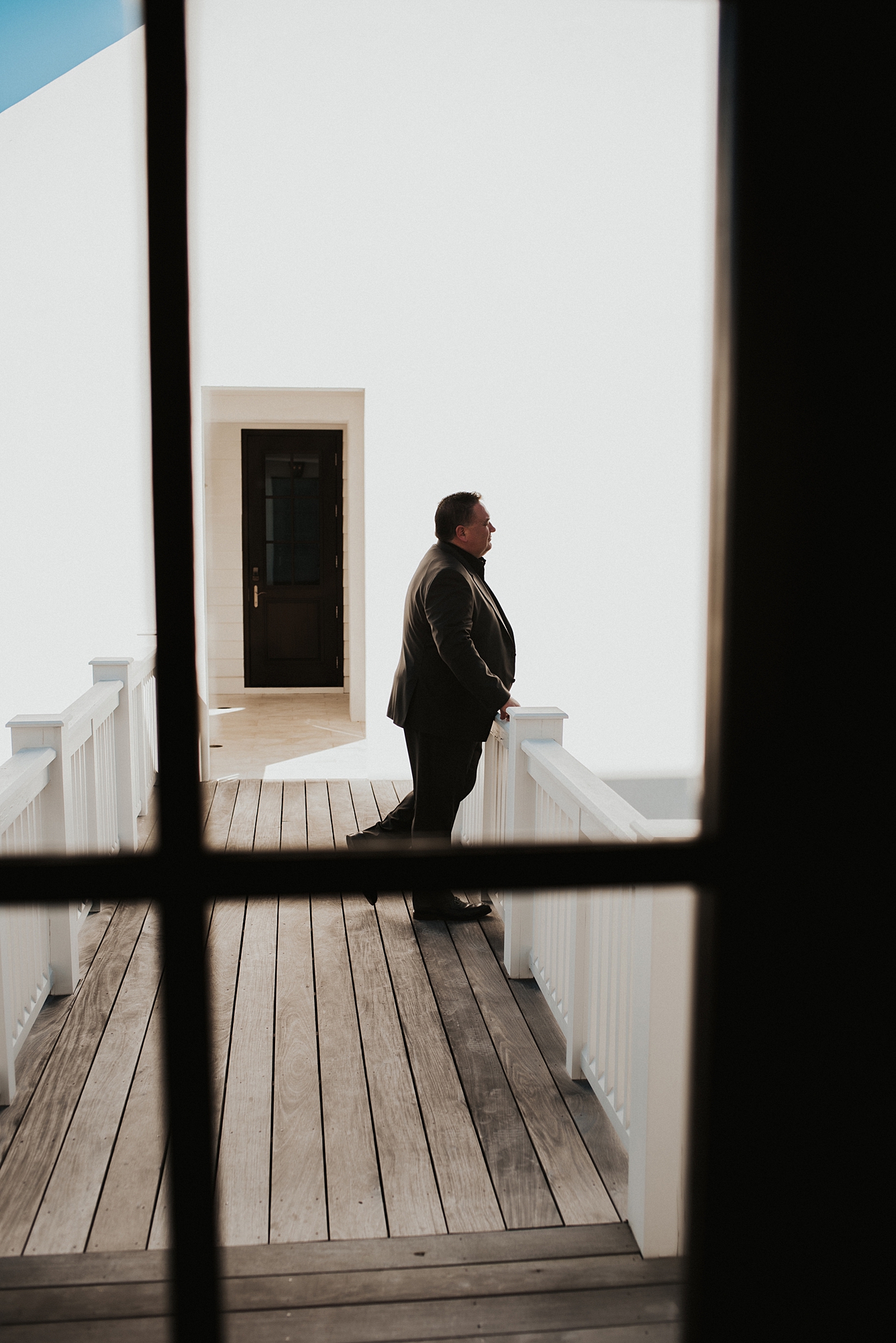 Groom patiently waiting on porch for first look with bride