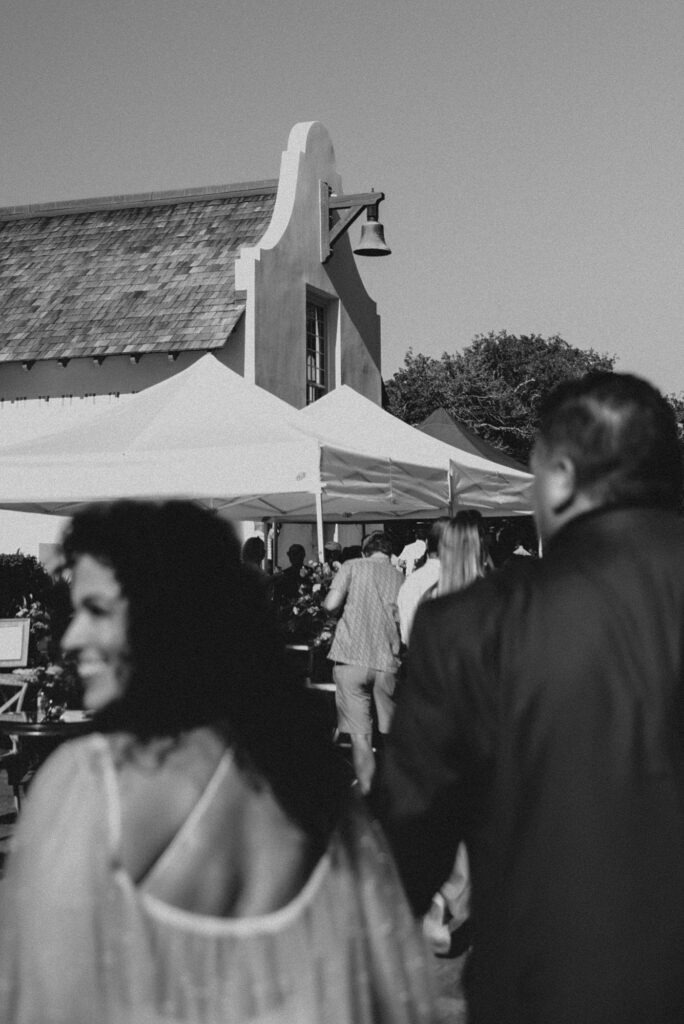 Bride and groom walking downtown out of focus with a church bell in focus