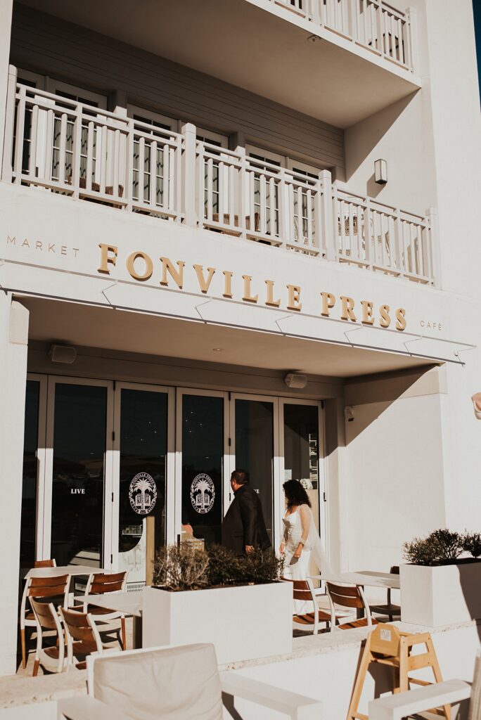 Bride and groom walking into Fonville Press in Rosemary Beach