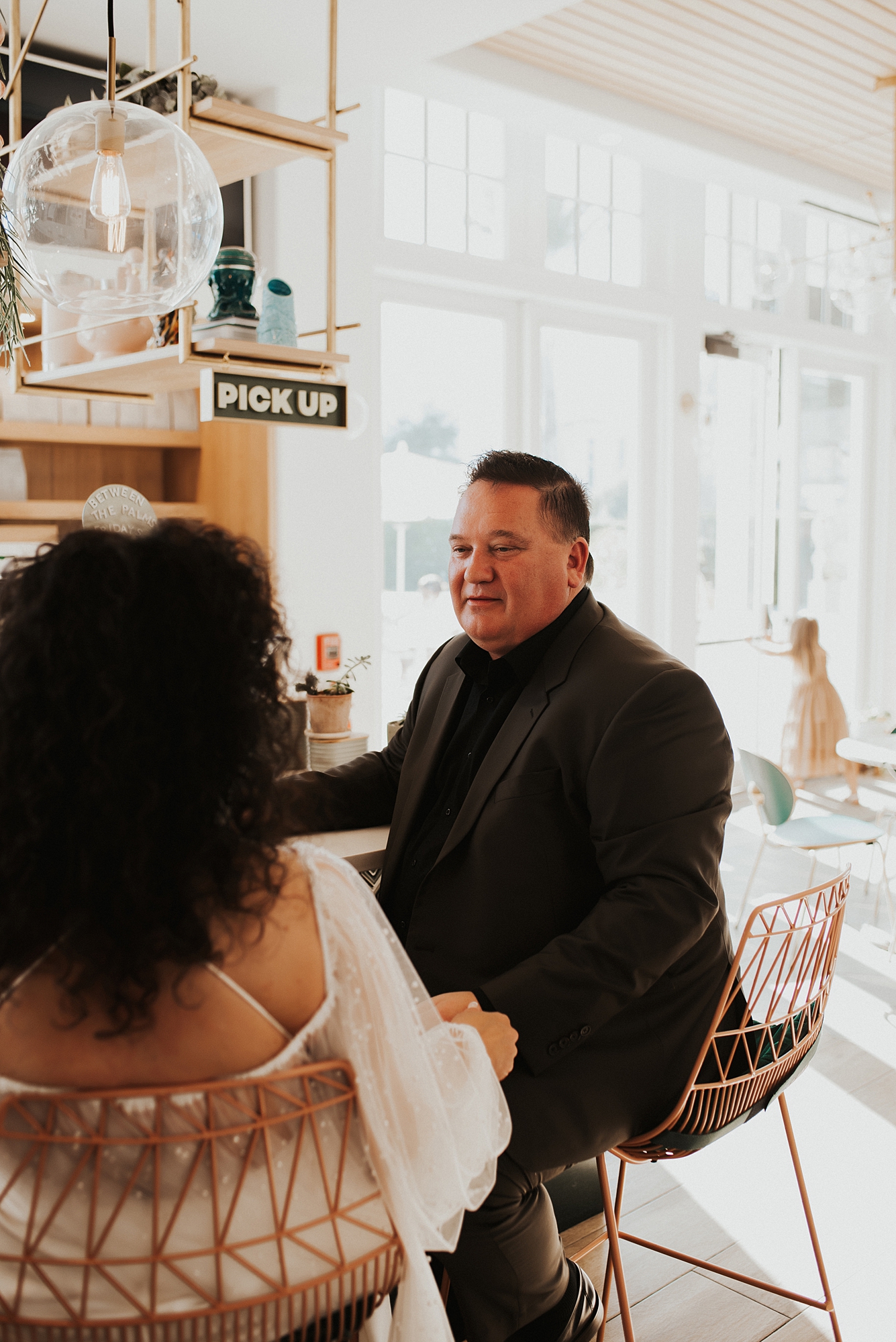 Groom sitting at bar of Fonville Press in Rosemary Beach