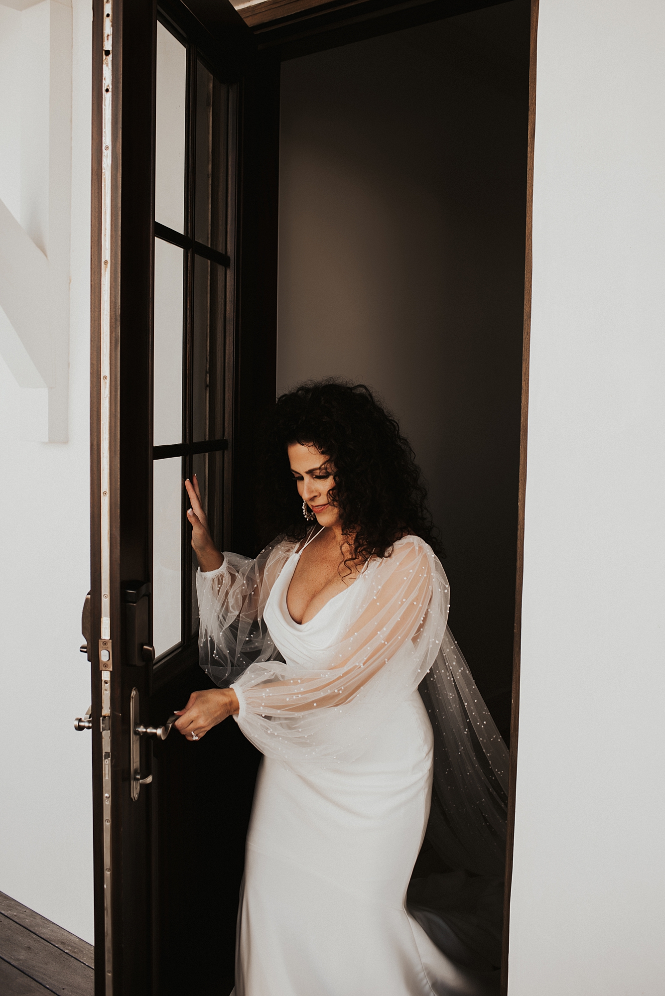 Bride walking through door for first look with groom